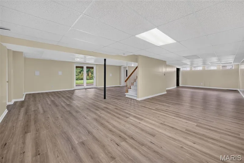 Spacious finished lower level with new flooring, recessed lighting, and direct outdoor access through double French doors. — 231 Renaldo Drive, Chesterfield, MO 63017
