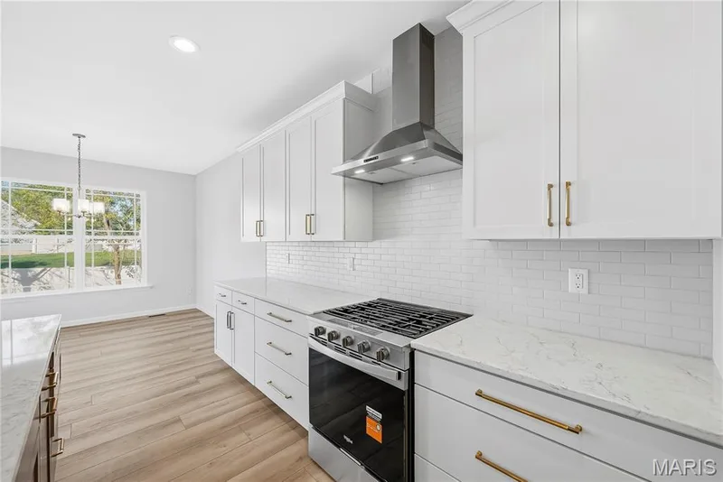 Gas Range, Stainless Steel Range Hood, Quartz Countertops and Tile Backsplash in Kitchen — 53 Pheasant Ring Drive, St Peters, MO 63376