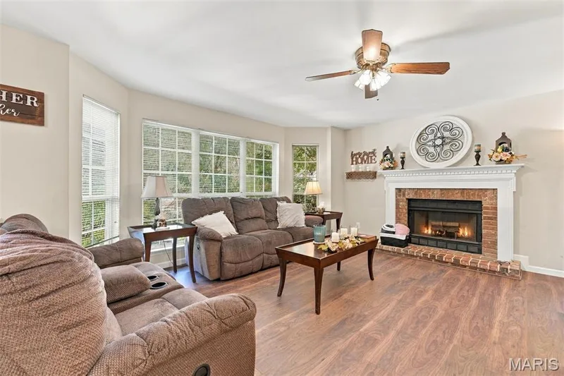 Family Room with Bay windows, luxury vinyl flooring, fireplace open to kitchen and sneak through to office — 5872 Wellington Farm Drive, St Charles, MO 63304