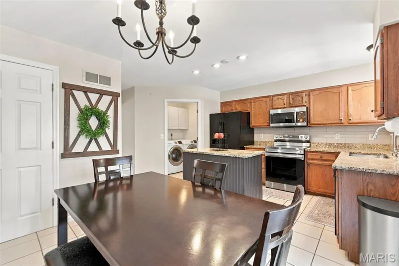 Kitchen and breakfast room open to family room and main floor laundry — 5872 Wellington Farm Drive, St Charles, MO 63304