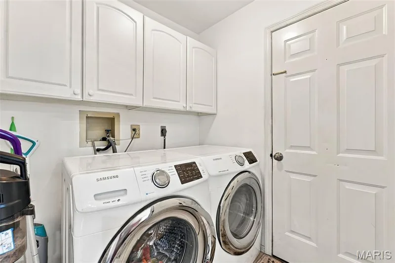 Main floor laundry with storage cabinets — 5872 Wellington Farm Drive, St Charles, MO 63304