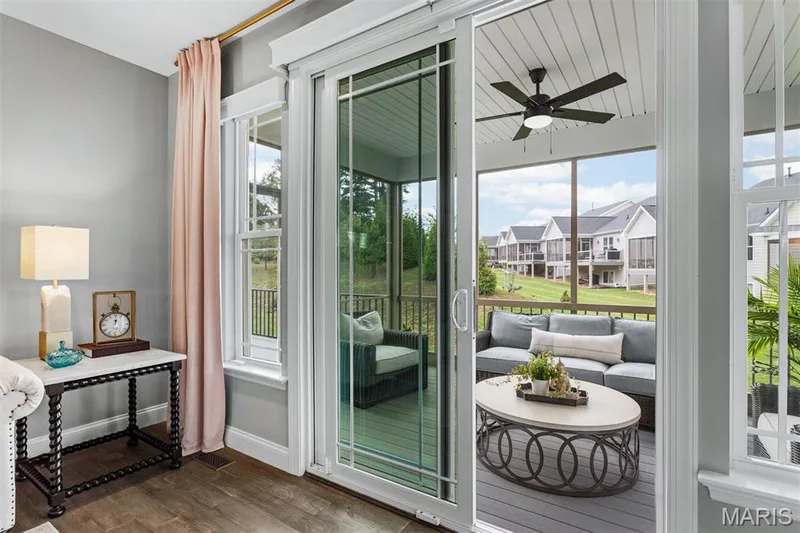 Sliding glass doors opening to a screened porch with a ceiling fan — 17028 Fire Glow Drive, Ballwin, MO 63011