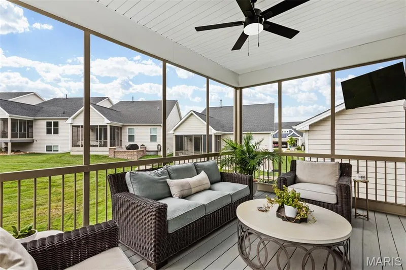 Screened outdoor living area with a ceiling fan, composite decking, and metal railings — 17028 Fire Glow Drive, Ballwin, MO 63011