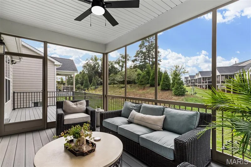 Expansive screened porch with a ceiling fan, composite decking, and a glass-paneled door — 17028 Fire Glow Drive, Ballwin, MO 63011