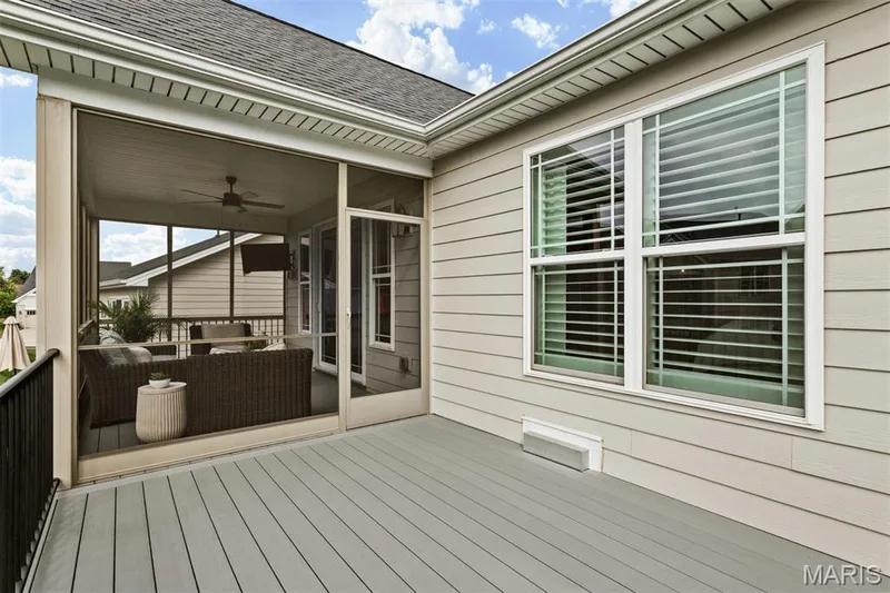 Expansive outdoor deck with composite decking, screened-in porch with ceiling fan, and light-colored siding — 17028 Fire Glow Drive, Ballwin, MO 63011