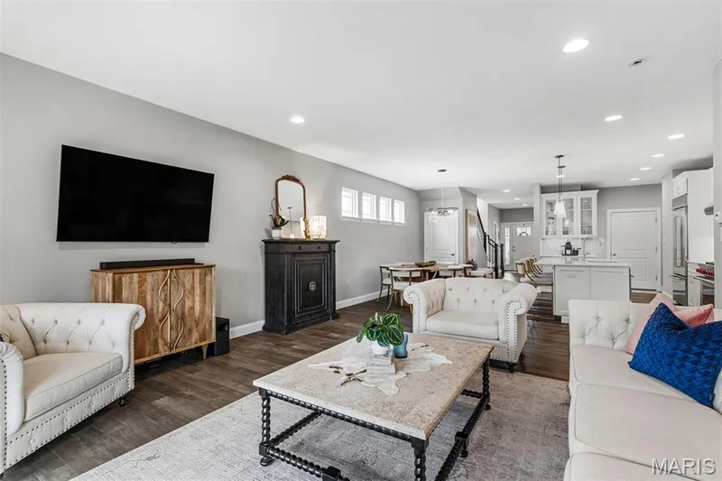 Open-concept living space featuring wood-finish flooring, recessed lighting, and a dining area with pendant lighting — 17028 Fire Glow Drive, Ballwin, MO 63011