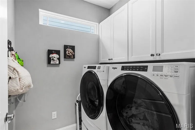 Upper white cabinetry, a high transom window, and a light gray wall — 17028 Fire Glow Drive, Ballwin, MO 63011