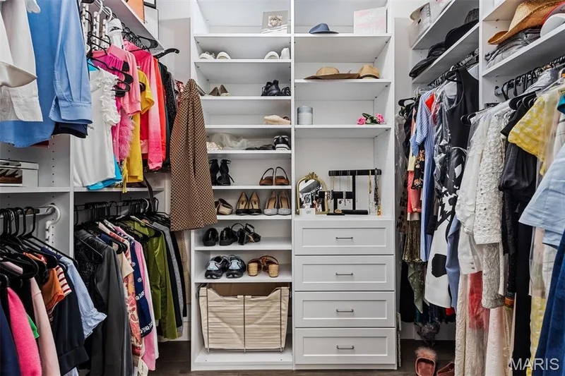 Custom closet system featuring multiple hanging rods, integrated shelving, and white drawer storage with brushed nickel hardware — 17028 Fire Glow Drive, Ballwin, MO 63011