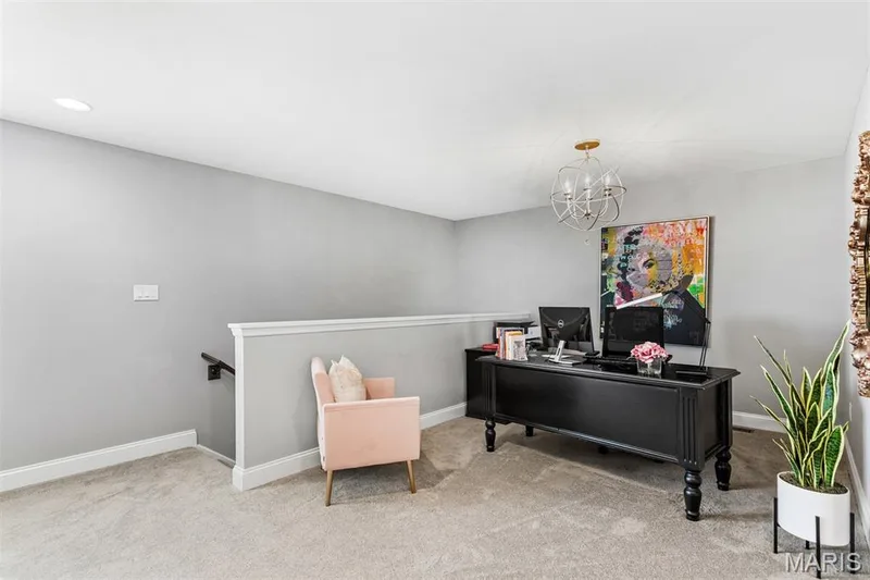 Carpeted room with a decorative chandelier, recessed lighting, and a white railing — 17028 Fire Glow Drive, Ballwin, MO 63011