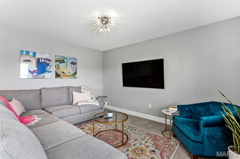 Recessed lighting with a contemporary ceiling fixture, mounted television, and light gray wall paint — 17028 Fire Glow Drive, Ballwin, MO 63011