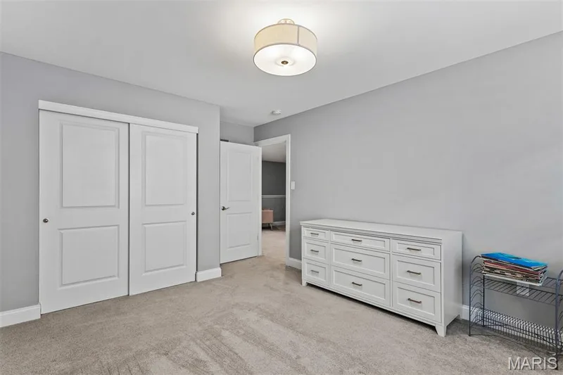 Textured gray carpeting, contemporary ceiling light fixture, and white bi-fold closet doors — 17028 Fire Glow Drive, Ballwin, MO 63011