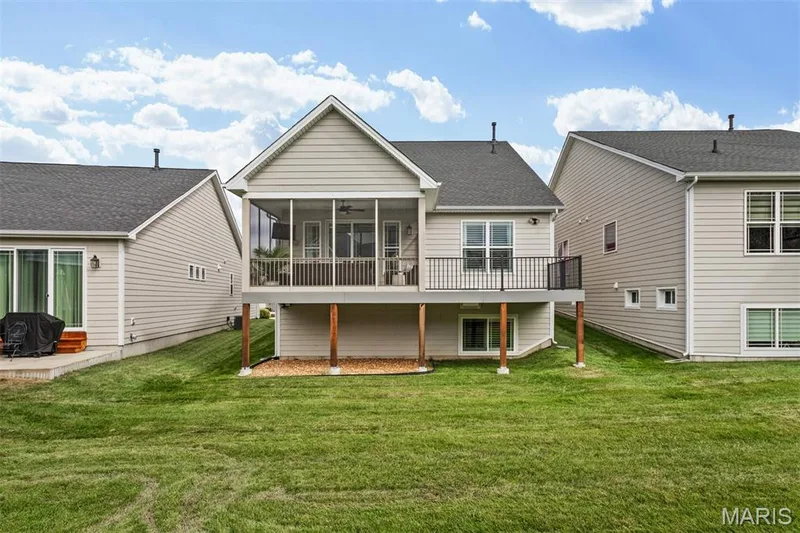Screened-in porch with ceiling fan, elevated deck with black metal railing, and a walk-out lower level — 17028 Fire Glow Drive, Ballwin, MO 63011