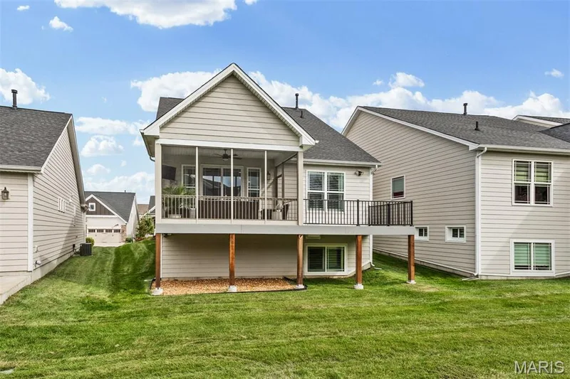 Screened porch, exterior deck, neutral-toned siding, dark roof shingles, lower-level windows — 17028 Fire Glow Drive, Ballwin, MO 63011