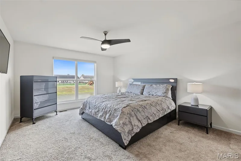 Expansive window, neutral wall paint, ceiling fan, and light-colored carpeting — 284 Crestfield Court, St Charles, MO 63301
