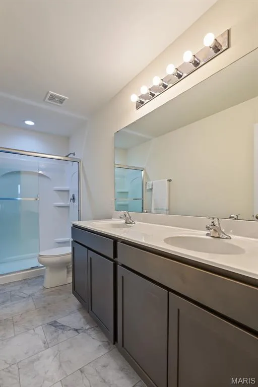 Dual vanity with integrated sinks, contemporary gray cabinetry, and a full-width mirror — 284 Crestfield Court, St Charles, MO 63301