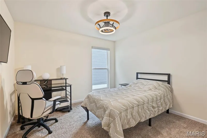 Neutral wall paint, carpet flooring, a window with horizontal blinds, and a contemporary ceiling fan with integrated lighting — 284 Crestfield Court, St Charles, MO 63301