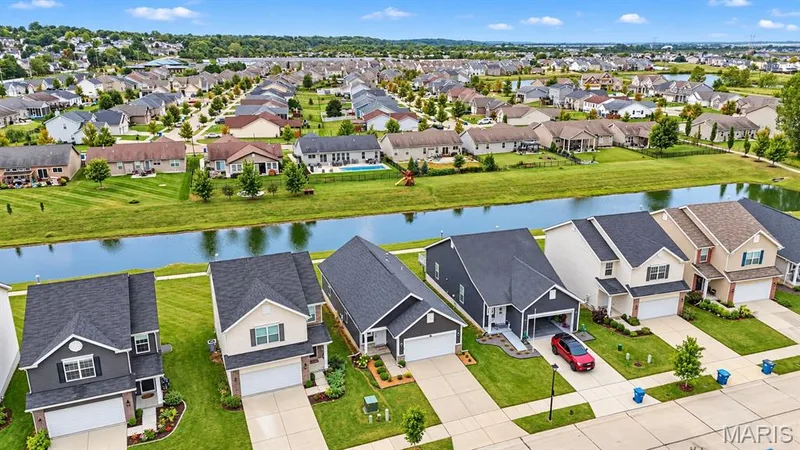 Residential neighborhood featuring varied home styles, manicured lawns, and a waterway — 284 Crestfield Court, St Charles, MO 63301