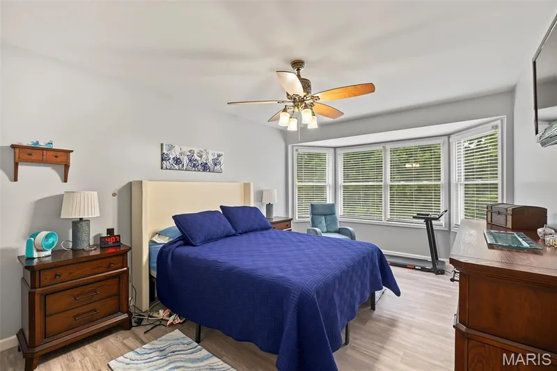 Bay window with multiple panels, vaulted ceiling, ceiling fan with integrated lighting, and wood-finish flooring — 8 Soenker Circle, St Peters, MO 63376