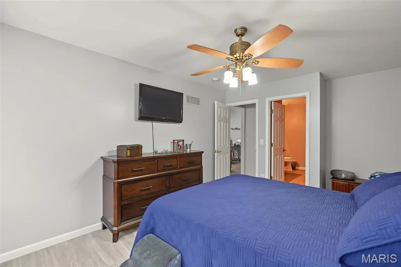 Wood-finish flooring, ceiling fan with integrated lighting, and neutral wall tones — 8 Soenker Circle, St Peters, MO 63376