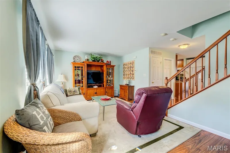 Wood-finish flooring, staircase with wood banister and spindles, light blue wall paint, and recessed lighting — 820 Brookmead Drive, O'Fallon, MO 63366