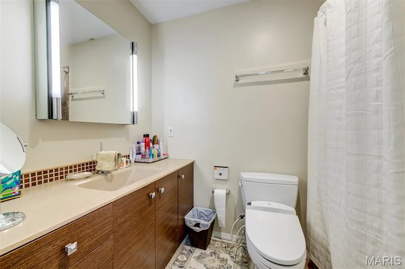 Extended single vanity with integrated sink and wood-finish cabinetry — 820 Brookmead Drive, O'Fallon, MO 63366