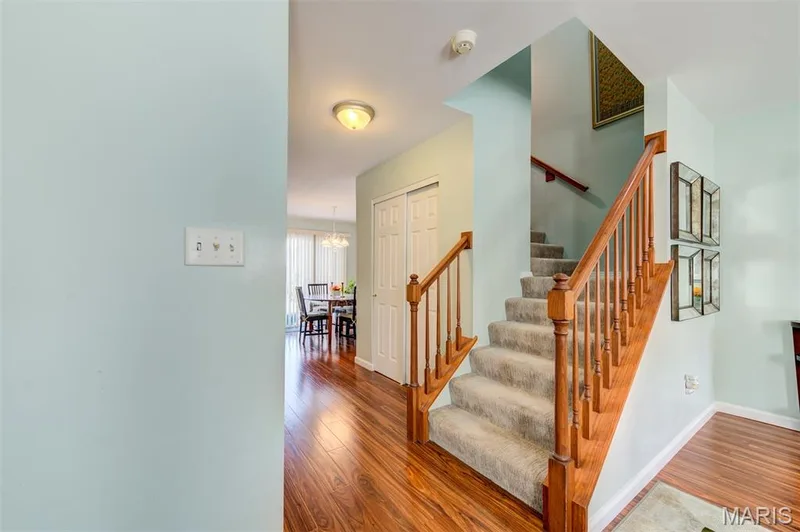 Staircase featuring wood-finish banister and carpeted treads — 820 Brookmead Drive, O'Fallon, MO 63366