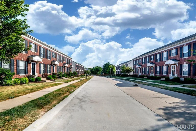 Brick exterior, black louvered shutters, white trim details, individual entryways, manicured landscaping — 820 Brookmead Drive, O'Fallon, MO 63366