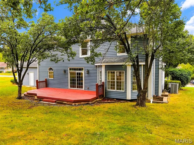 Expansive red-stained deck with white railings, featuring direct access via sliding glass doors — 11 Silver Leaf Court, Lake St. Louis, MO 63367