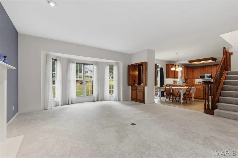Recessed lighting, bay window, built-in cabinetry, wood-finish staircase, and kitchen with wood cabinetry — 11 Silver Leaf Court, Lake St. Louis, MO 63367