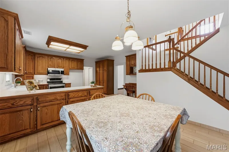 Kitchen featuring wood-finish cabinetry, white countertops, and stainless steel appliances — 11 Silver Leaf Court, Lake St. Louis, MO 63367