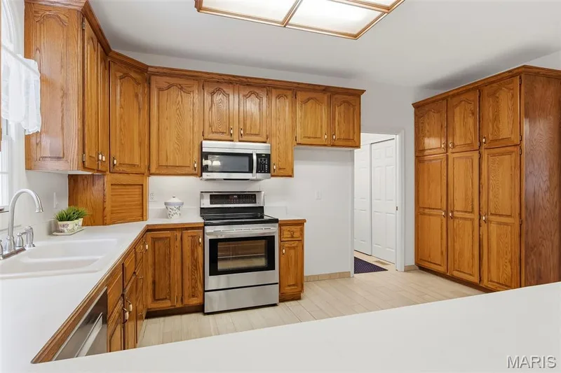 Full kitchen featuring extensive wood cabinetry and an integrated stainless steel appliance suite — 11 Silver Leaf Court, Lake St. Louis, MO 63367