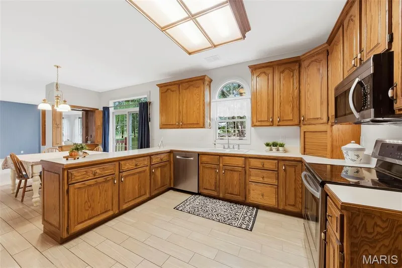 Kitchen featuring wood cabinetry, white countertops, stainless steel appliances, and a tiled floor — 11 Silver Leaf Court, Lake St. Louis, MO 63367