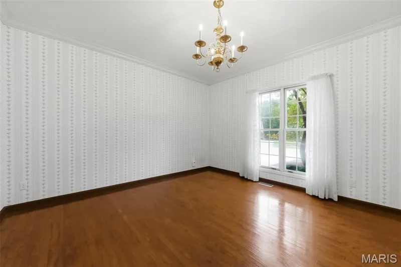 Hardwood flooring and crown molding complement patterned wallpaper — 11 Silver Leaf Court, Lake St. Louis, MO 63367