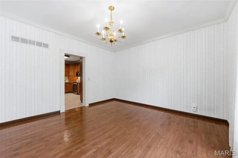 Hardwood flooring, crown molding, patterned wallpaper, and a brass chandelier — 11 Silver Leaf Court, Lake St. Louis, MO 63367
