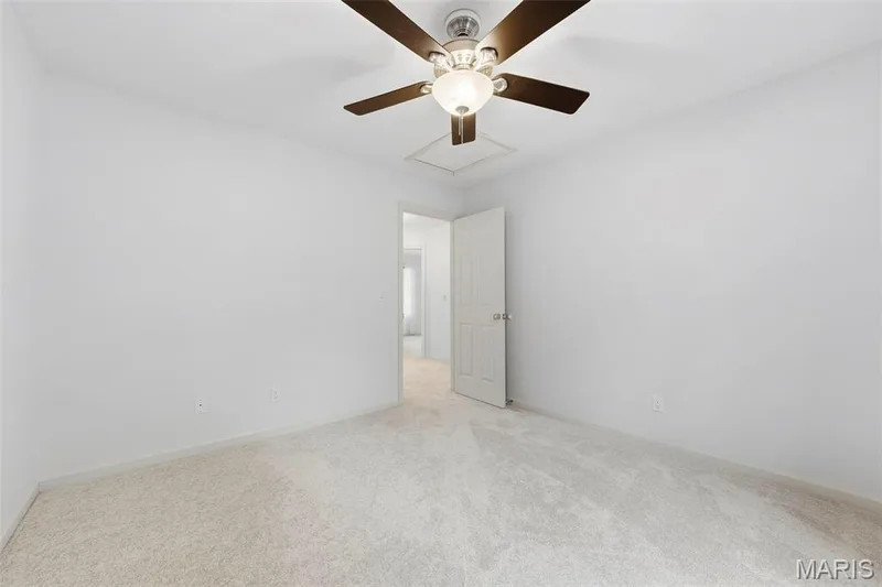 Wall-to-wall carpeting, ceiling fan with integrated lighting, and a white interior door — 11 Silver Leaf Court, Lake St. Louis, MO 63367