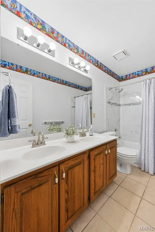 Double vanity with wood-finish cabinetry, dual undermount sinks, and a white countertop — 11 Silver Leaf Court, Lake St. Louis, MO 63367