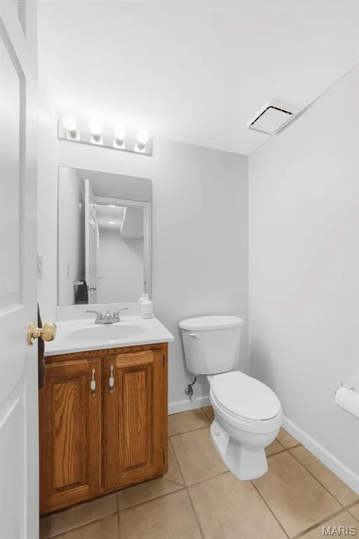 Wood-finish vanity with a white countertop sink and polished chrome faucet — 11 Silver Leaf Court, Lake St. Louis, MO 63367