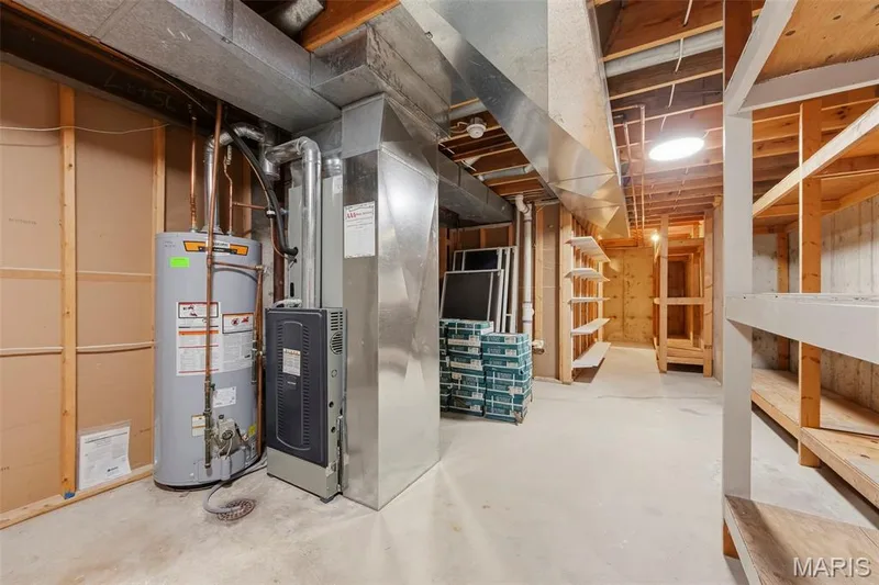 Utility room with concrete flooring, exposed ceiling joists, and a hot water heater — 11 Silver Leaf Court, Lake St. Louis, MO 63367