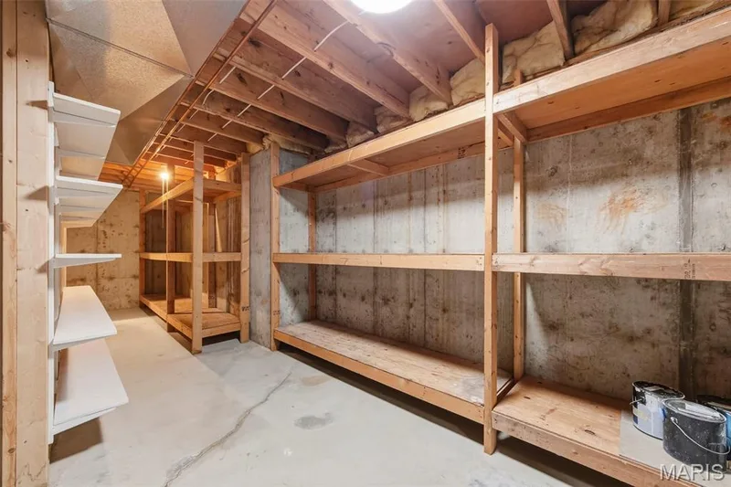 Exposed ceiling joists, concrete flooring, and built-in wood shelving units — 11 Silver Leaf Court, Lake St. Louis, MO 63367