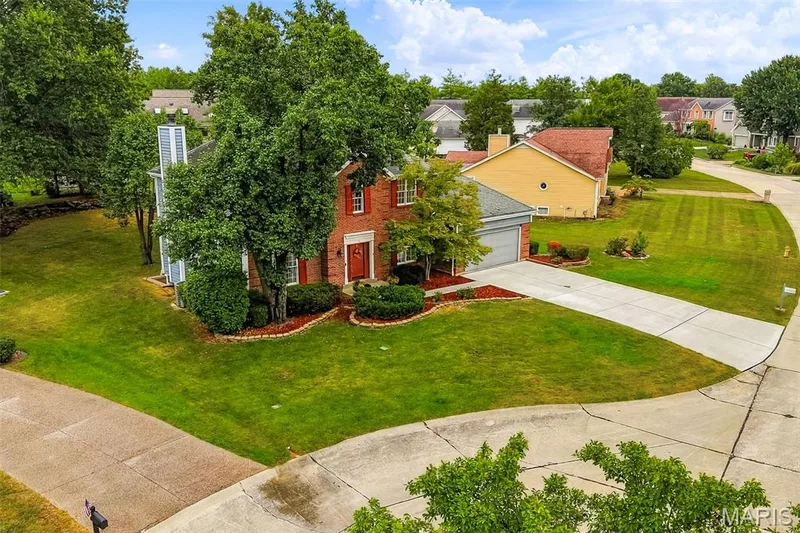 Brick exterior, attached garage, concrete driveway, mature trees, landscaped planting beds — 11 Silver Leaf Court, Lake St. Louis, MO 63367