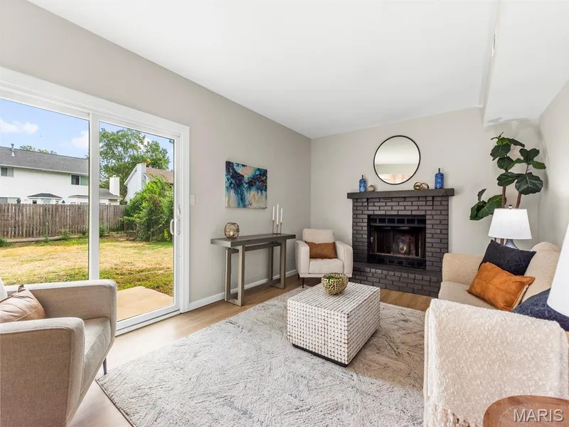 Living area featuring a dark brick fireplace and new LVP flooring — 920 Blake Court, St Peters, MO 63376