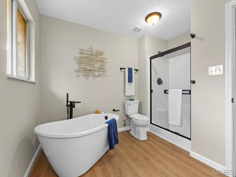 Freestanding soaking tub with a floor-mounted fixture, walk-in shower with a glass enclosure — 920 Blake Court, St Peters, MO 63376