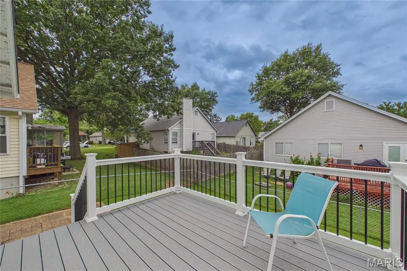 Rear deck featuring composite decking, white railings with black spindles, and a manicured lawn — 2931 Plum Leaf Circle, St Peters, MO 63303