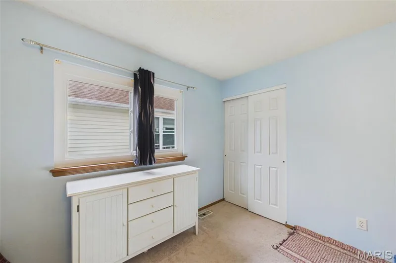 Window with wood trim and a sliding two-panel closet door with light colored carpeting — 2931 Plum Leaf Circle, St Peters, MO 63303