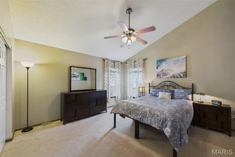 Vaulted ceiling with ceiling fan and light fixture, light neutral wall color, and wall-to-wall carpeting — 2931 Plum Leaf Circle, St Peters, MO 63303