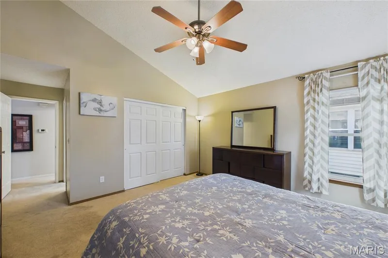 Vaulted ceiling with Oversized wall to wall closet Attached ceiling fan and light fixture, neutral wall paint, and carpeted flooring — 2931 Plum Leaf Circle, St Peters, MO 63303