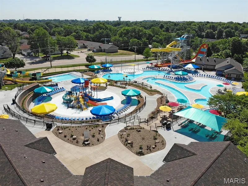 Expansive water park featuring multiple swimming pools, a lazy river, water slides, splash pads, and shaded lounge areas — 202 Kunze Drive, St Charles, MO 63303