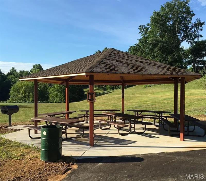 Gazebo with shingle roof and multiple picnic tables on a concrete pad — 202 Kunze Drive, St Charles, MO 63303