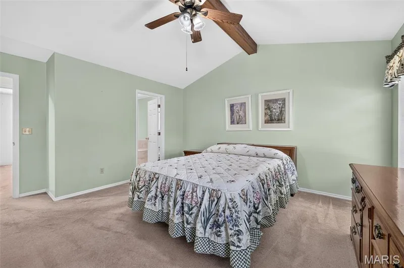 Vaulted Ceiling with Beam, Ceiling Fan, and Door to Primary Bathroom — 1436 Snowbird Lane, O'Fallon, MO 63366