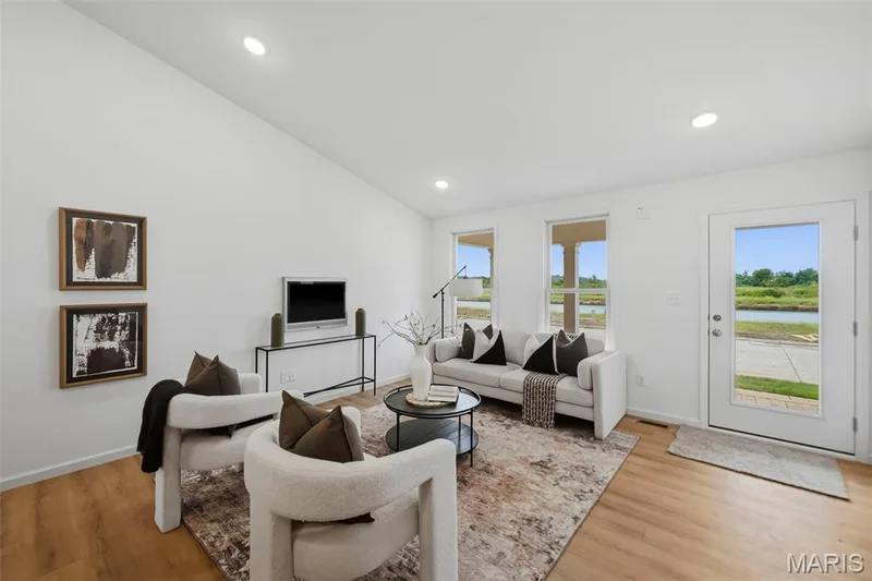 Vaulted ceiling with recessed lighting, LVP flooring, multiple windows, and a glass-paneled exterior door — 9023 Wilkie Station Street, St Charles, MO 63301